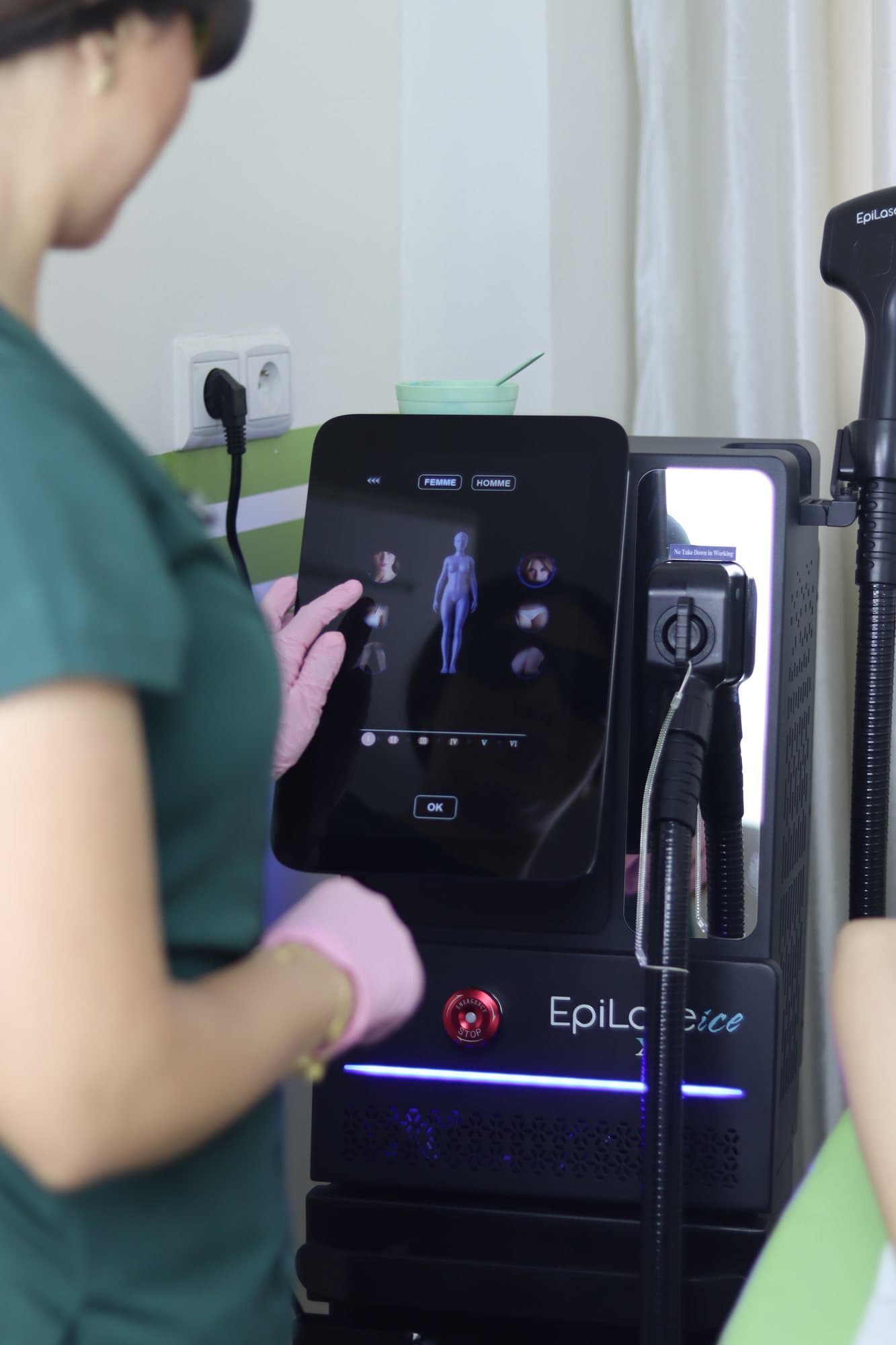 Praticienne réglant l'appareil d'épilation laser du cabinet