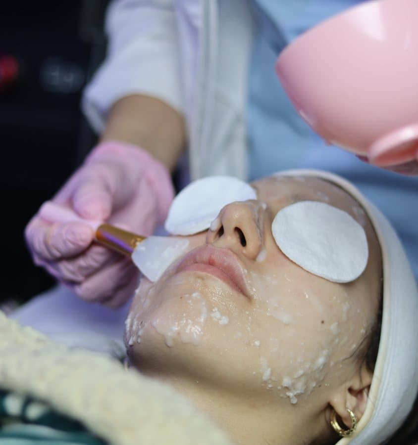 Application d'un masque apaisant au pinceau, les yeux protégés