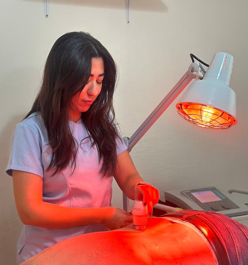 Kinésithérapeute traitant un patient sous lampe infrarouge